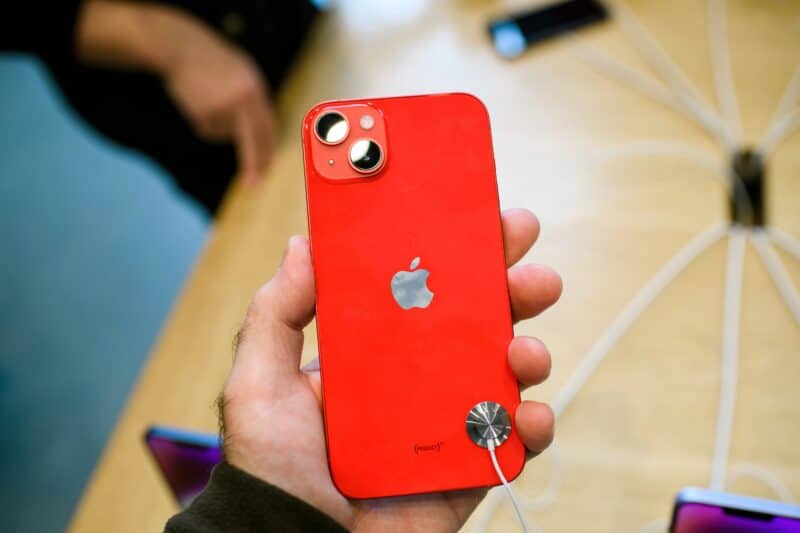 Mão segurando um iPhone 14 Plus vermelho