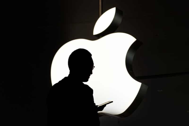 Silhueta de pessoa em frente ao logo da Apple