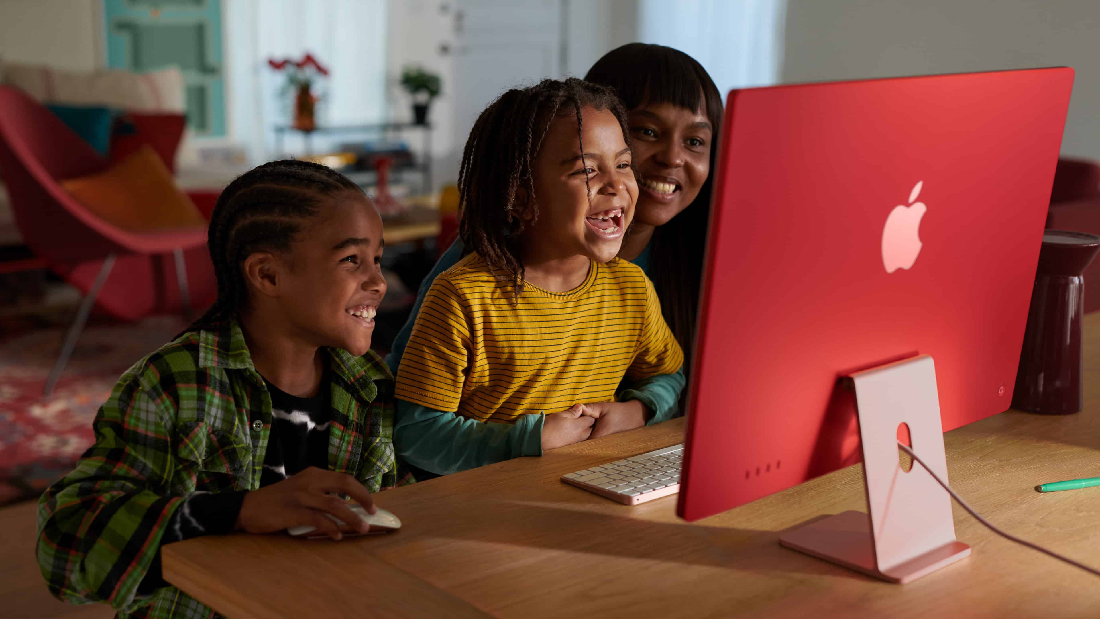 Crianças e mãe usando um iMac de 24" (M3) felizes