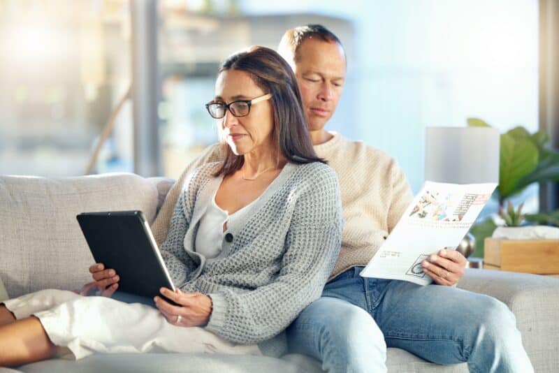 Casal em sofá com a mulher usando um iPad