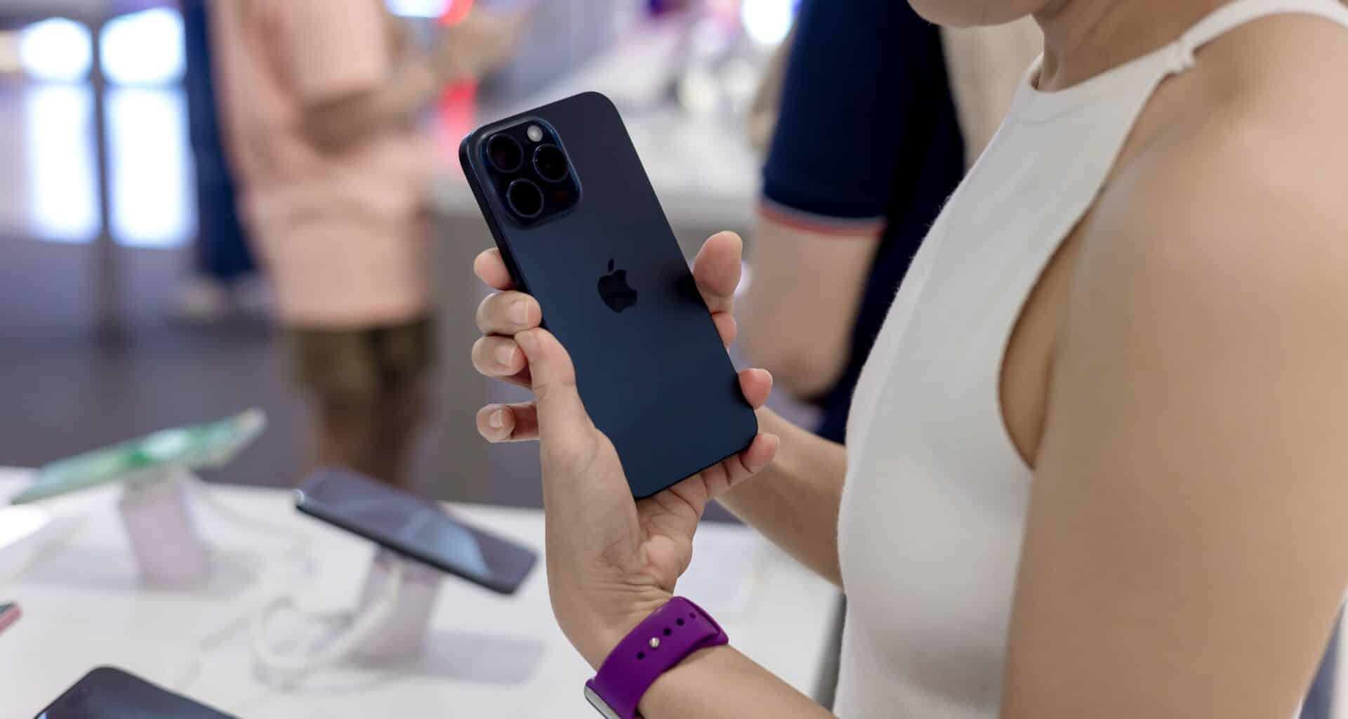 Mulher segurando iPhone 15 Pro Max em Apple Store