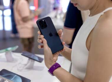 Mulher segurando iPhone 15 Pro Max em Apple Store