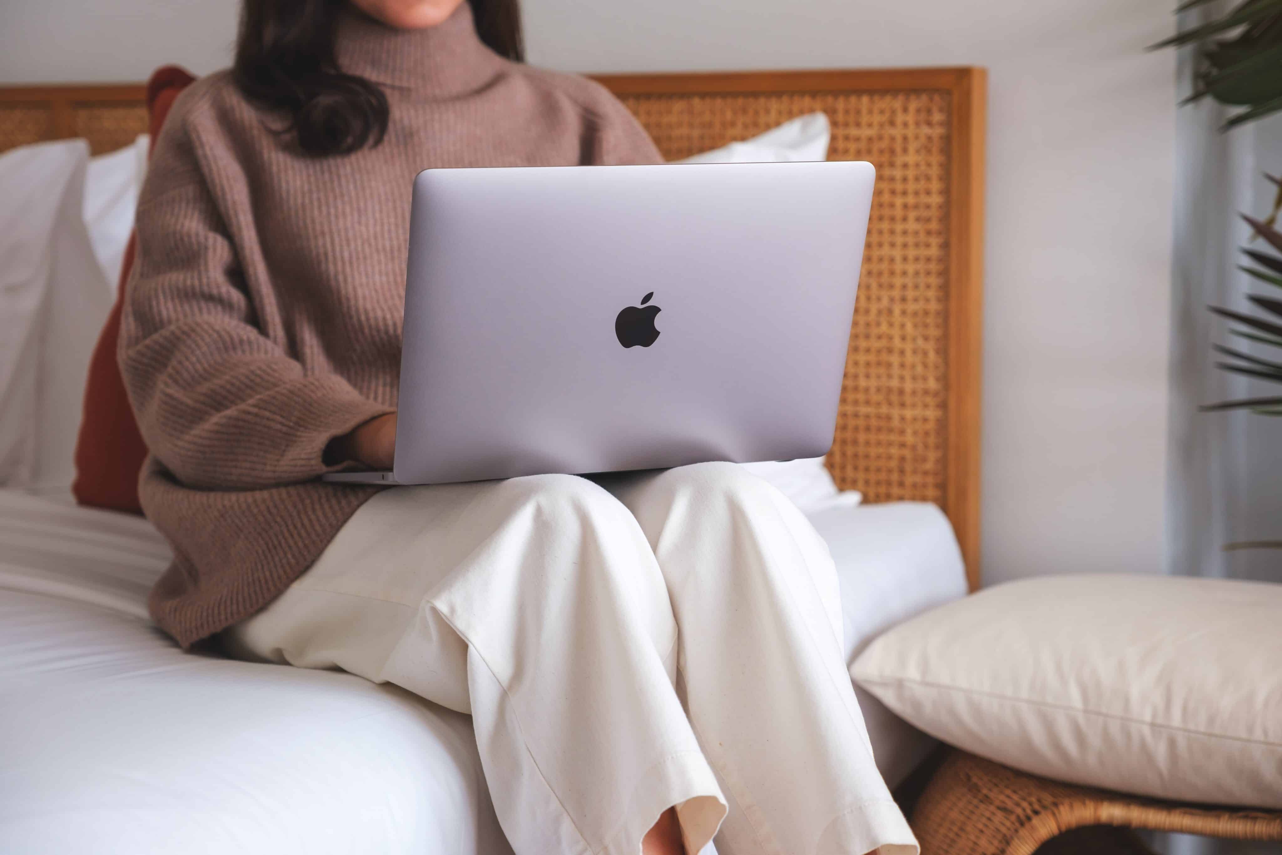 Mulher usando um MacBook Air/Pro na cama