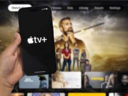 iPhone 14 Pro com o logo do Apple TV+ em frente a uma Apple TV
