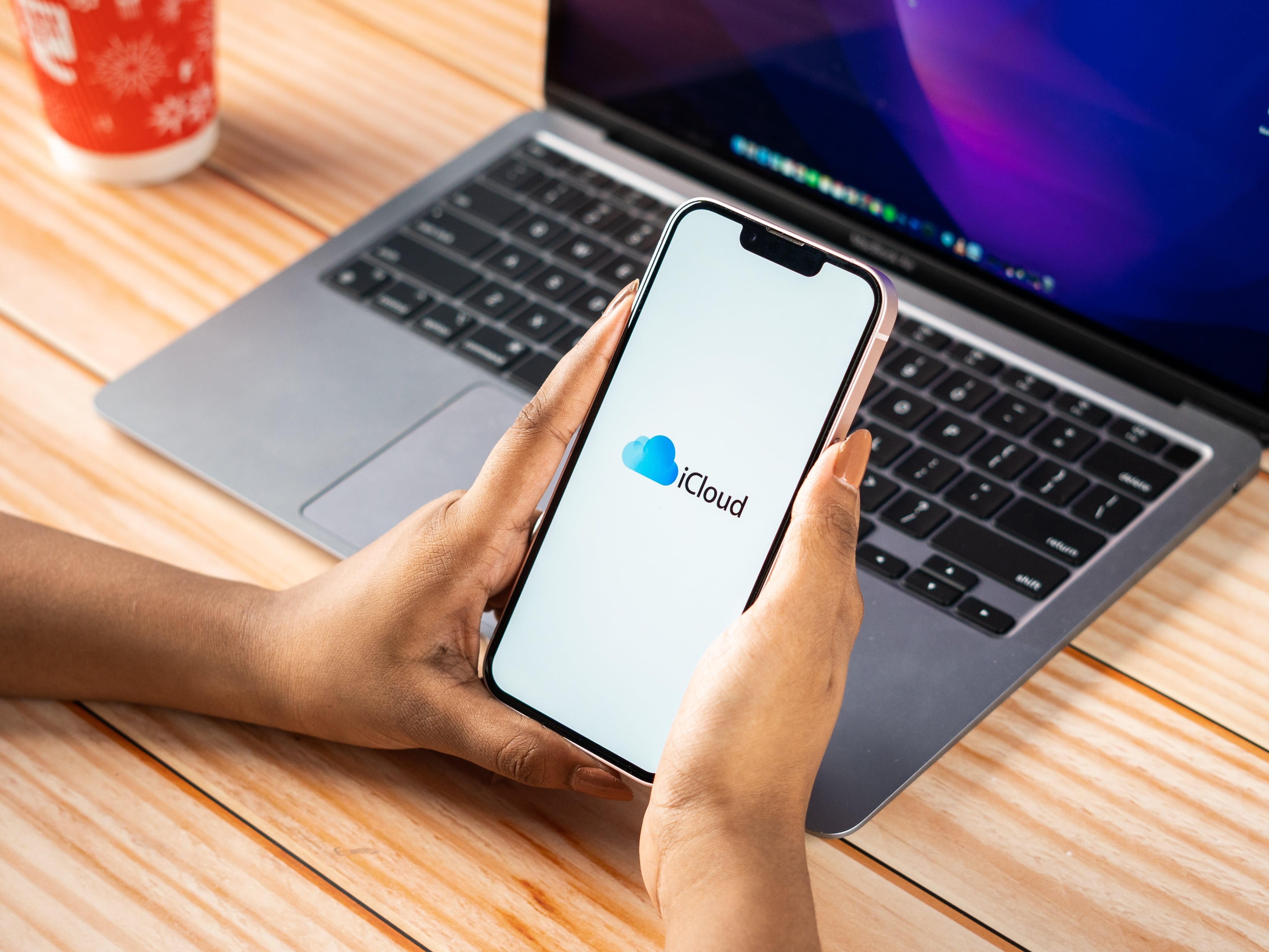 iPhone com o logo do iCloud e um Mac ao fundo