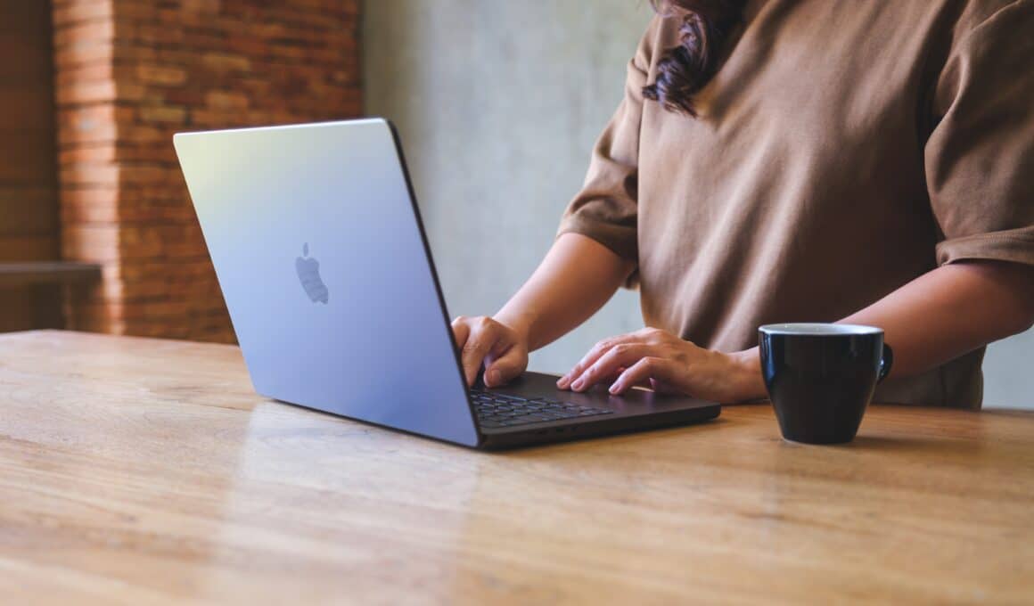 Mulher trabalhando num MacBook Pro com café ao lado