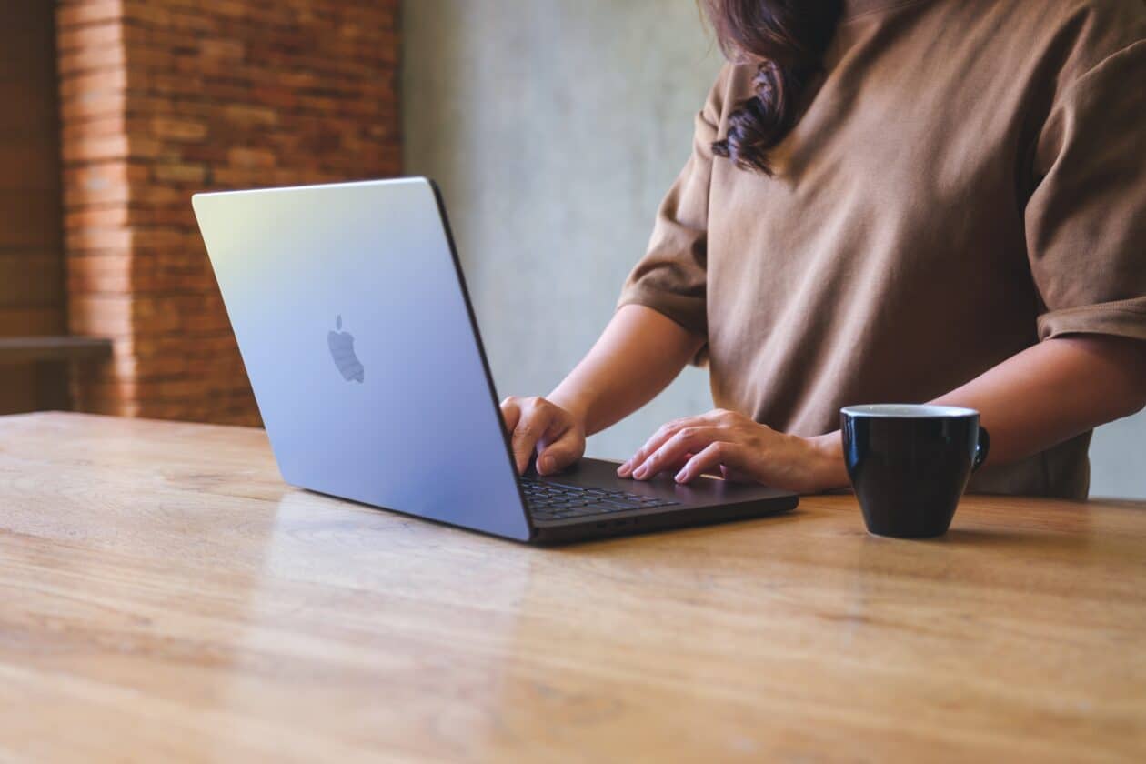 Mulher trabalhando num MacBook Pro com café ao lado