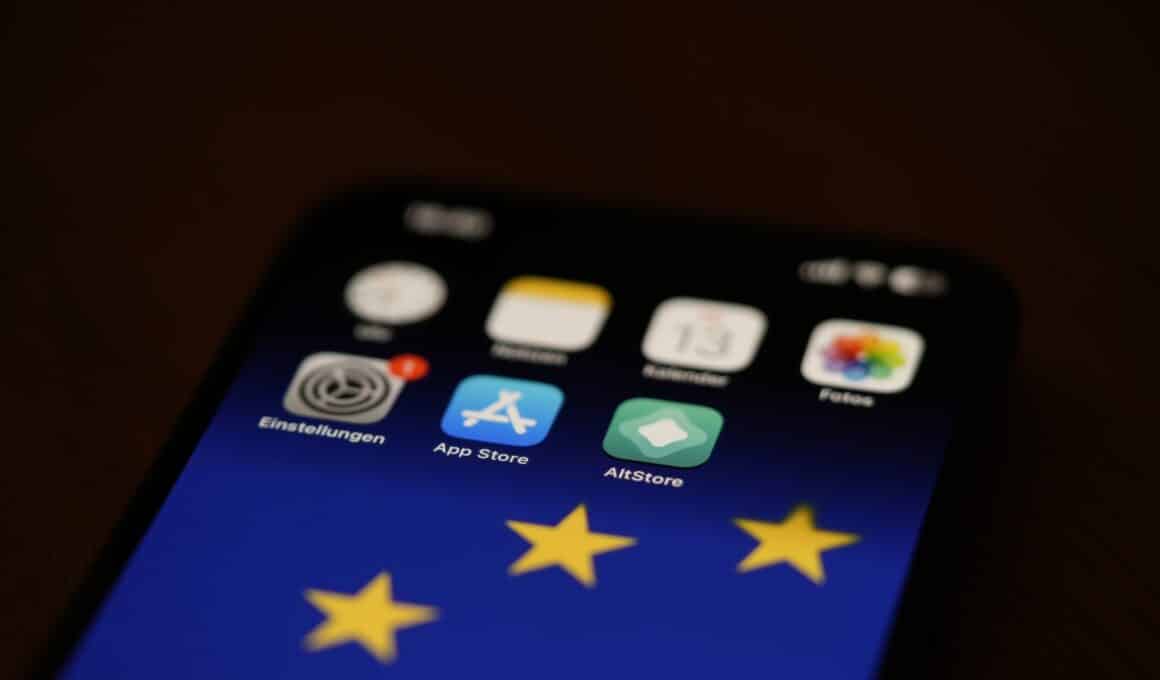 Ícones da App Store e da AltStore em um iPhone com a bandeira da União Europeia na tela de Início