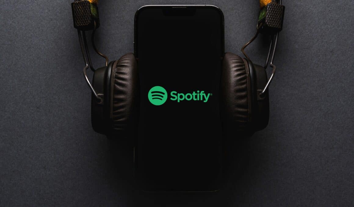 iPhone com o logo do Spotify e fones de ouvido