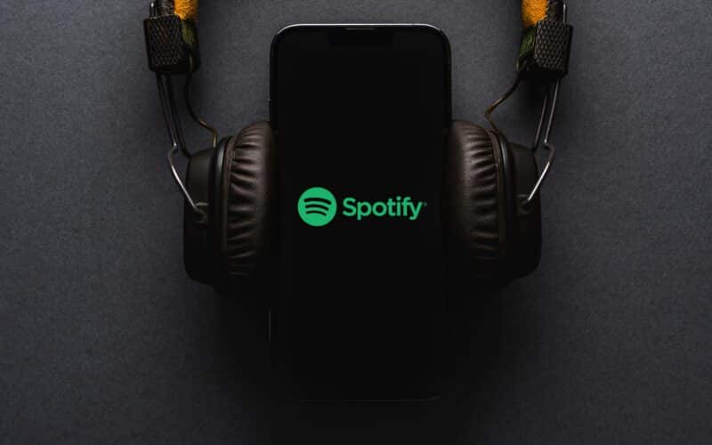 iPhone com o logo do Spotify e fones de ouvido