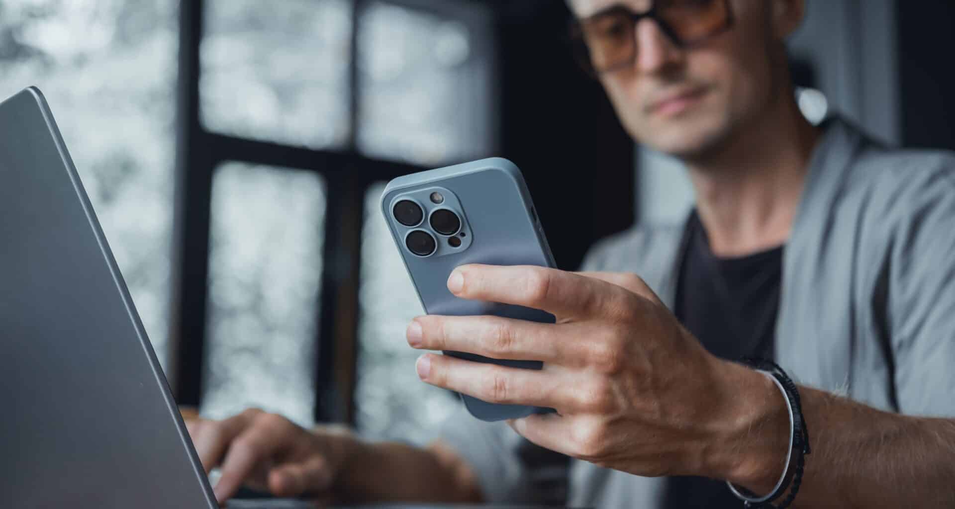 Homem usando um MacBook Pro e um iPhone
