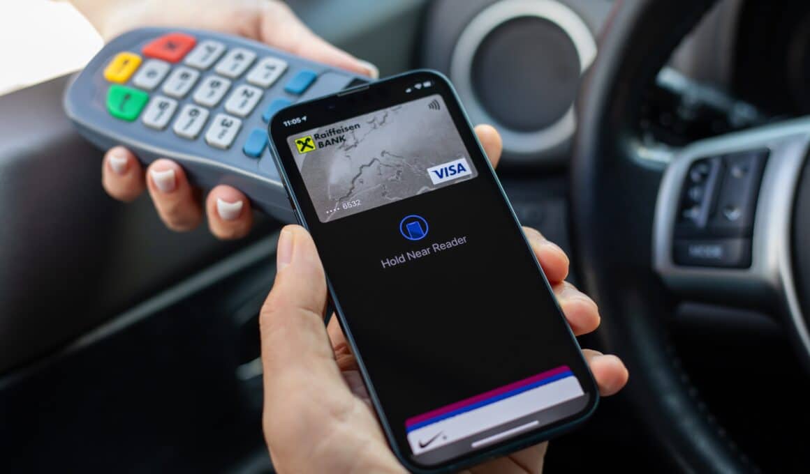 iPhone próximo de máquina de cartão para pagando sem contato via Apple Pay