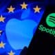 Logo do Spotify em dispotivo móvel e logo da Apple na bandeira da União Europeia