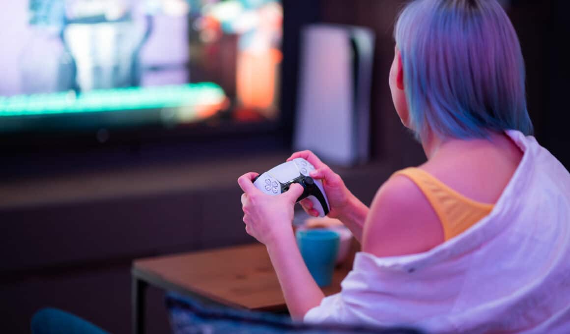 Mulher jogando com um controle DualSense, do PlayStation