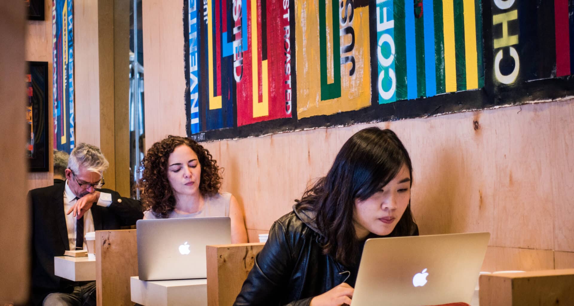 Pessoas trabalhando em Macs num café em Nova York