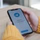Mão segurando iPhone com o app Telegram abrindo