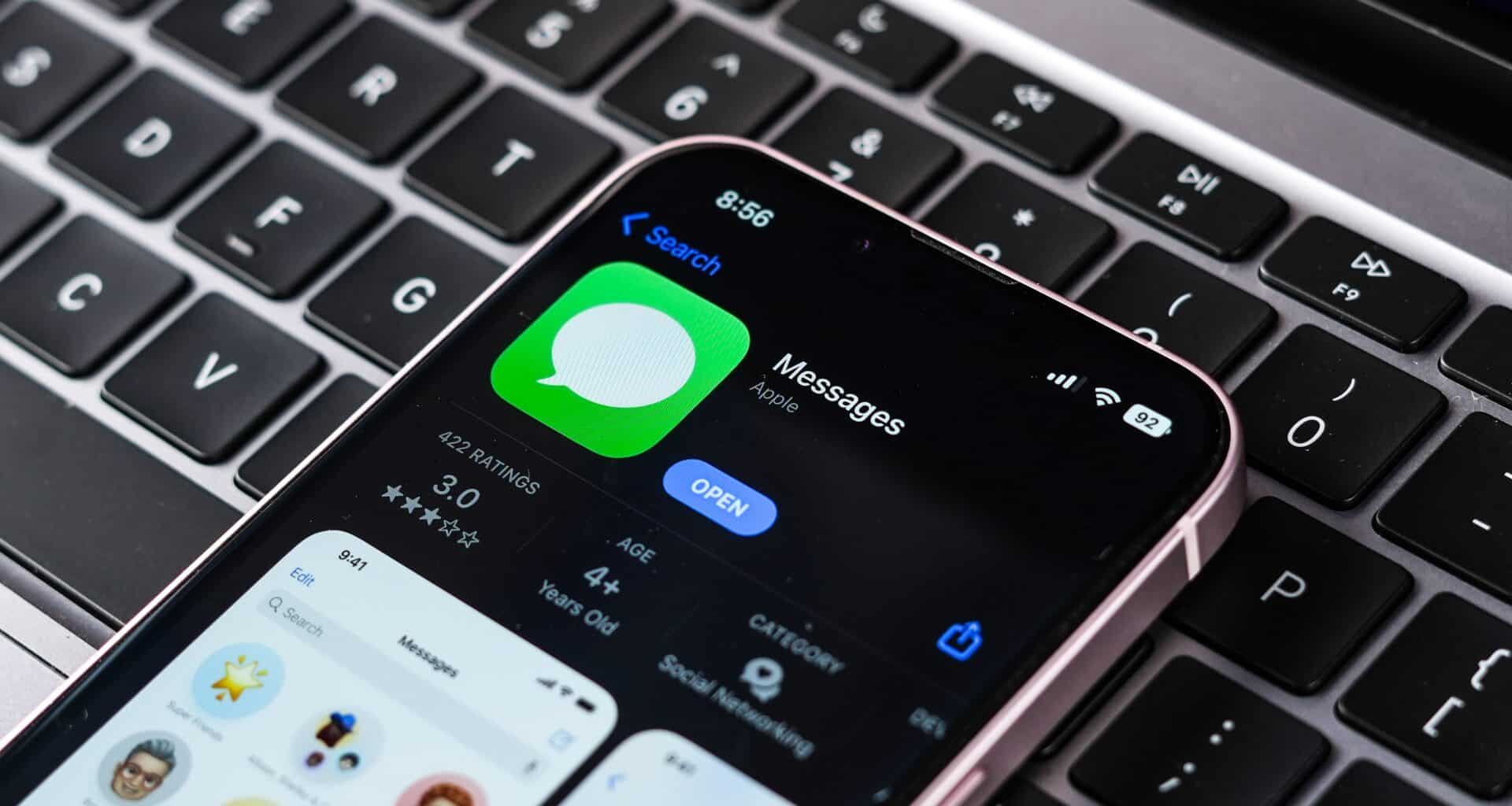 App Mensagens na App Store de um iPhone, que está em cima de um teclado de Mac