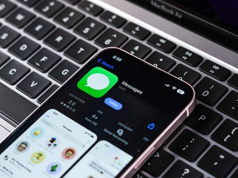App Mensagens na App Store de um iPhone, que está em cima de um teclado de Mac