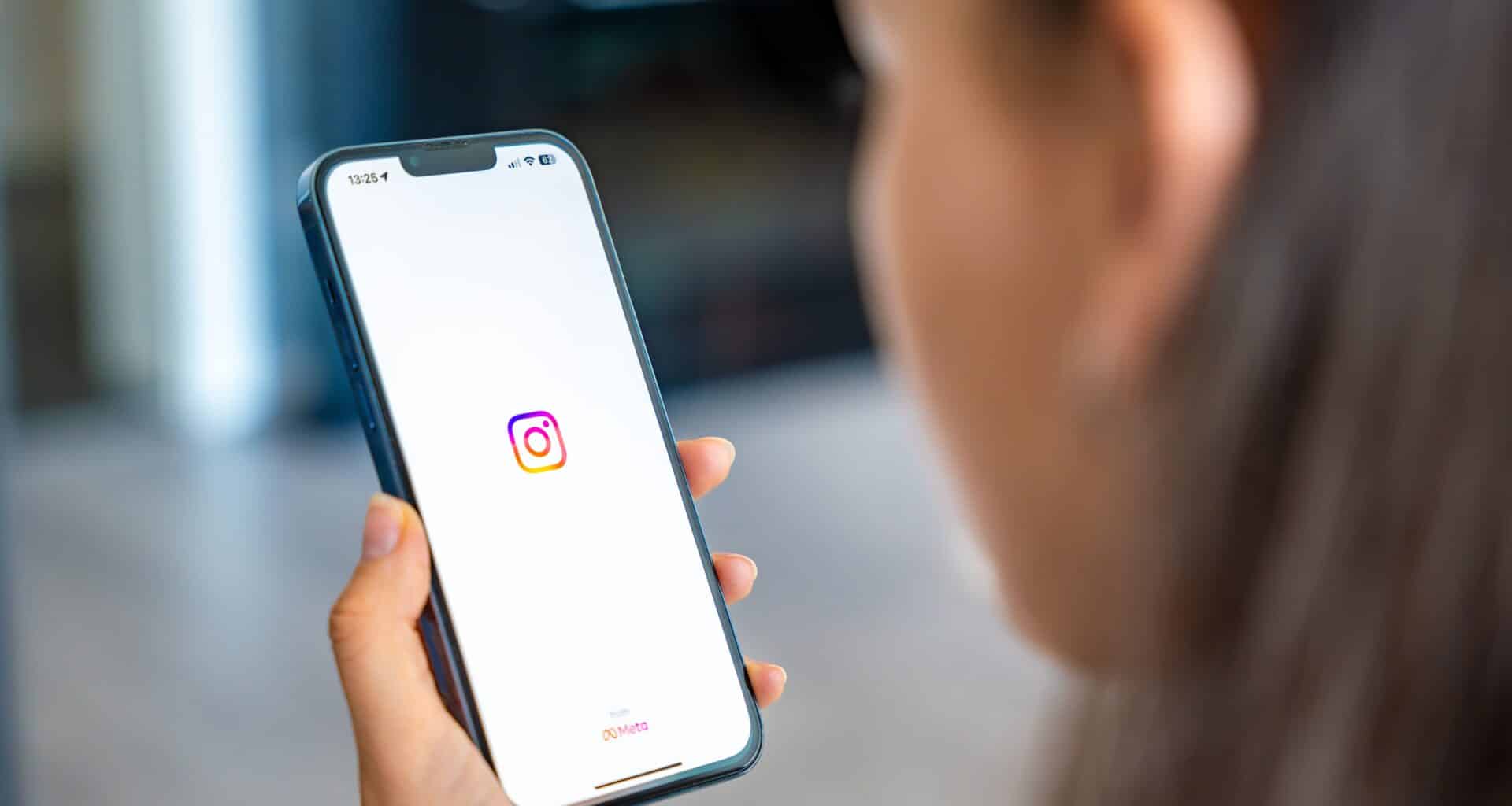 Mulher segurando um iPhone rodando o app Instagram