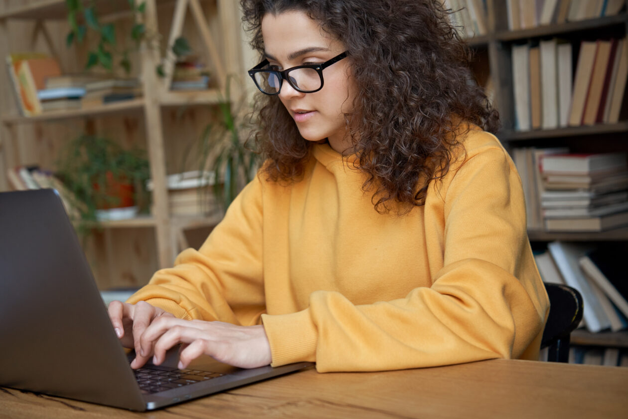 Garota/mulher digitando e trabalhando em um MacBook