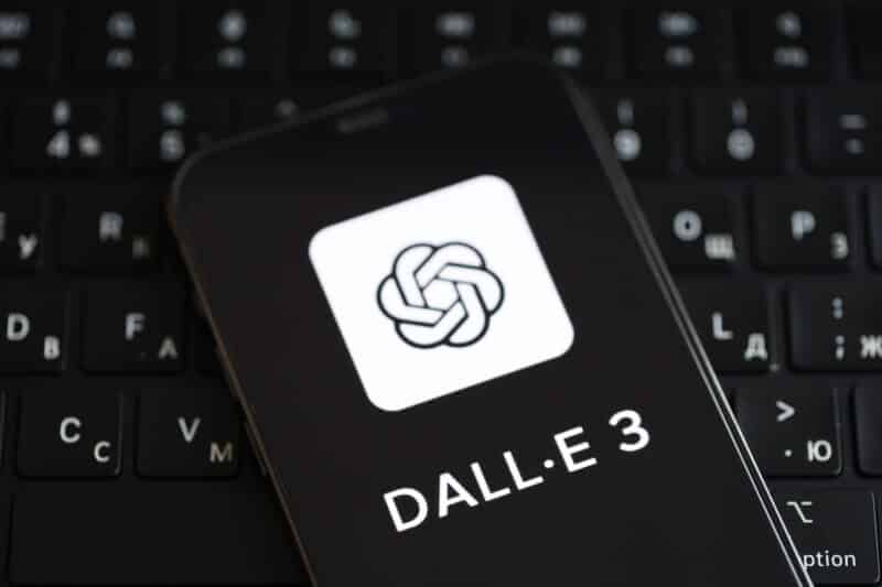 Logo do ChatGPT e do DALL-E 3 na tela do iPhone sob o teclado do MacBook