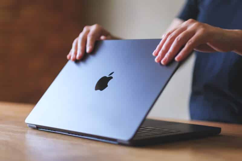 Mulher abrindo um MacBook Pro