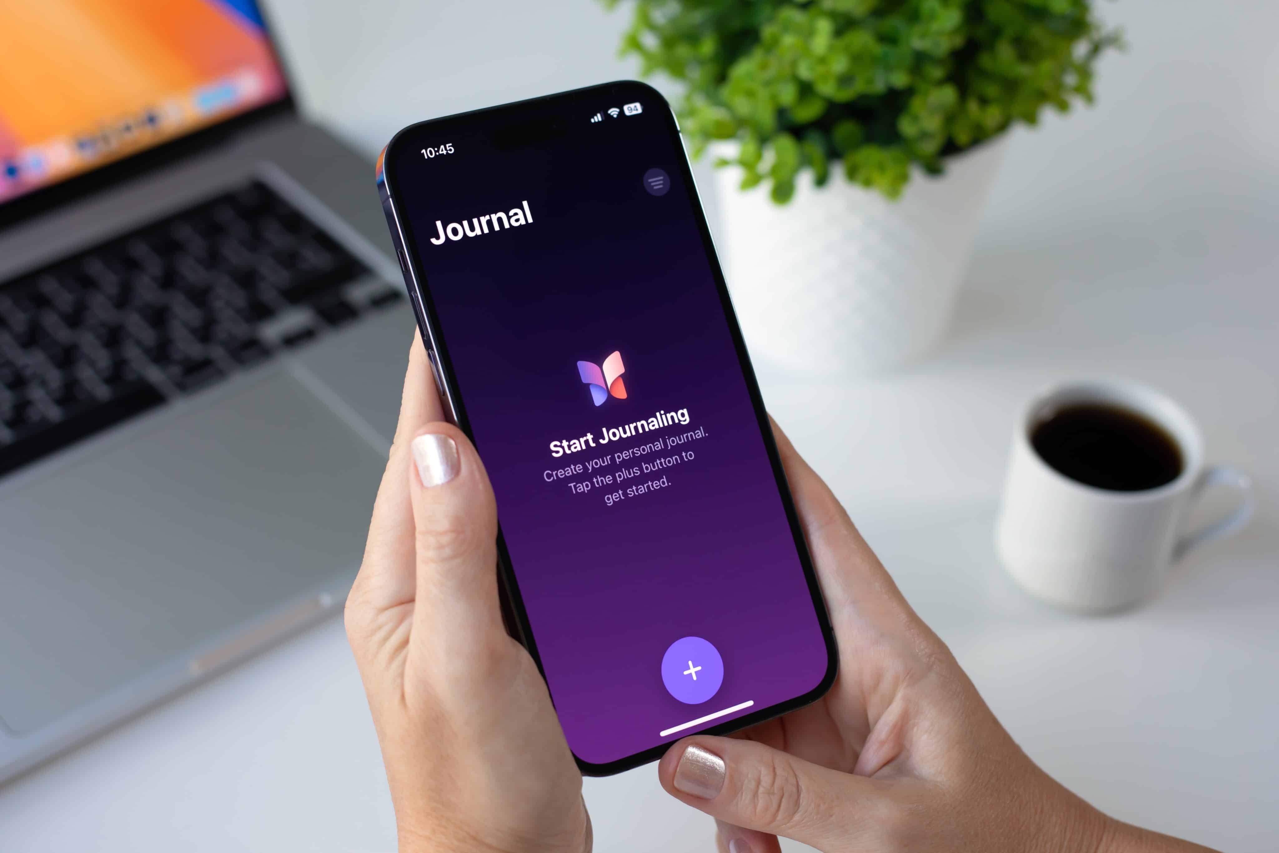 App Diário (Journal) no iPhone com um Mac ao fundo