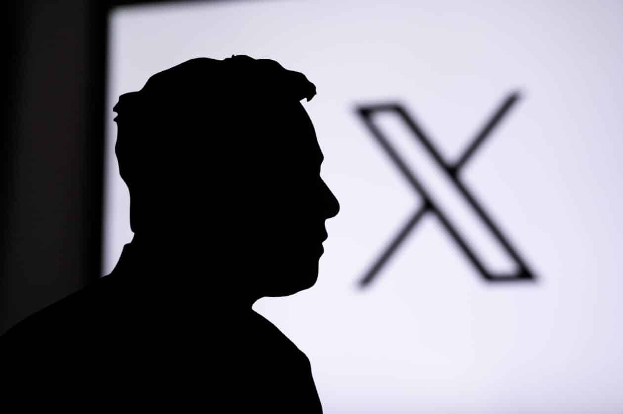Silhueta de Elon Musk em primeiro plano e o logo do X em segundo plano