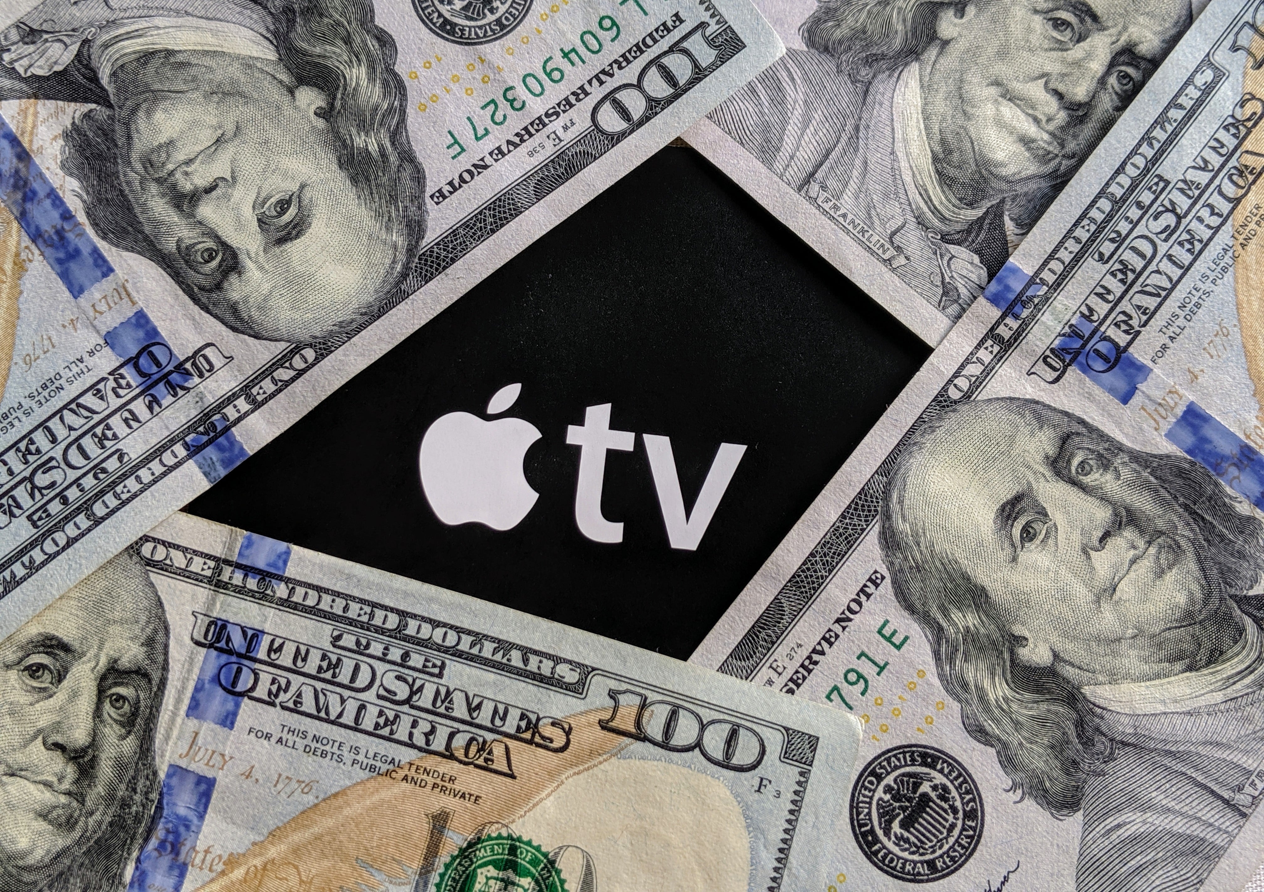 Notas de dinheiro (dólar) em torno do logo da Apple TV