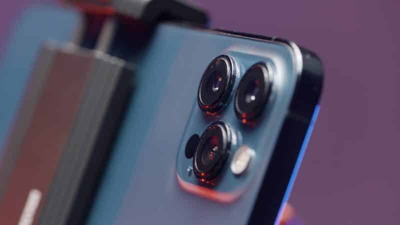 Close-up das câmeras de um iPhone 13 Pro Max fixado em um stand
