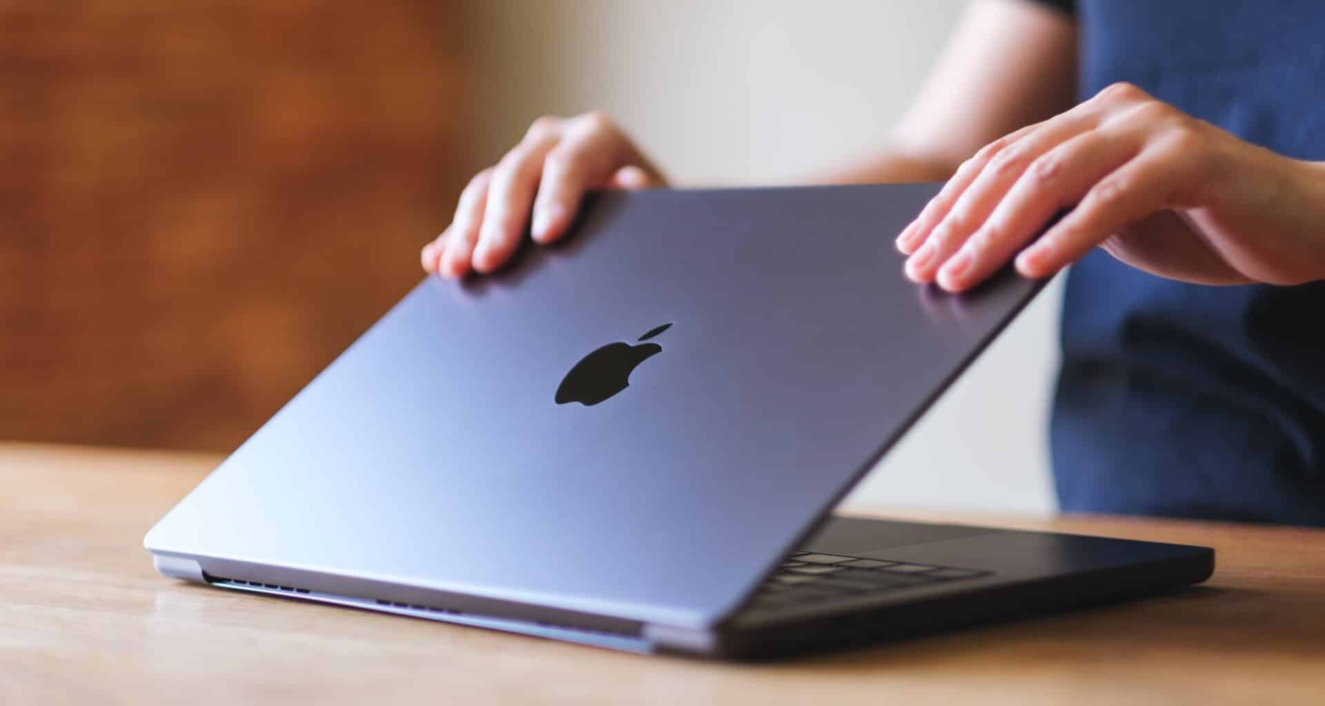 Pessoa abrindo um MacBook Pro