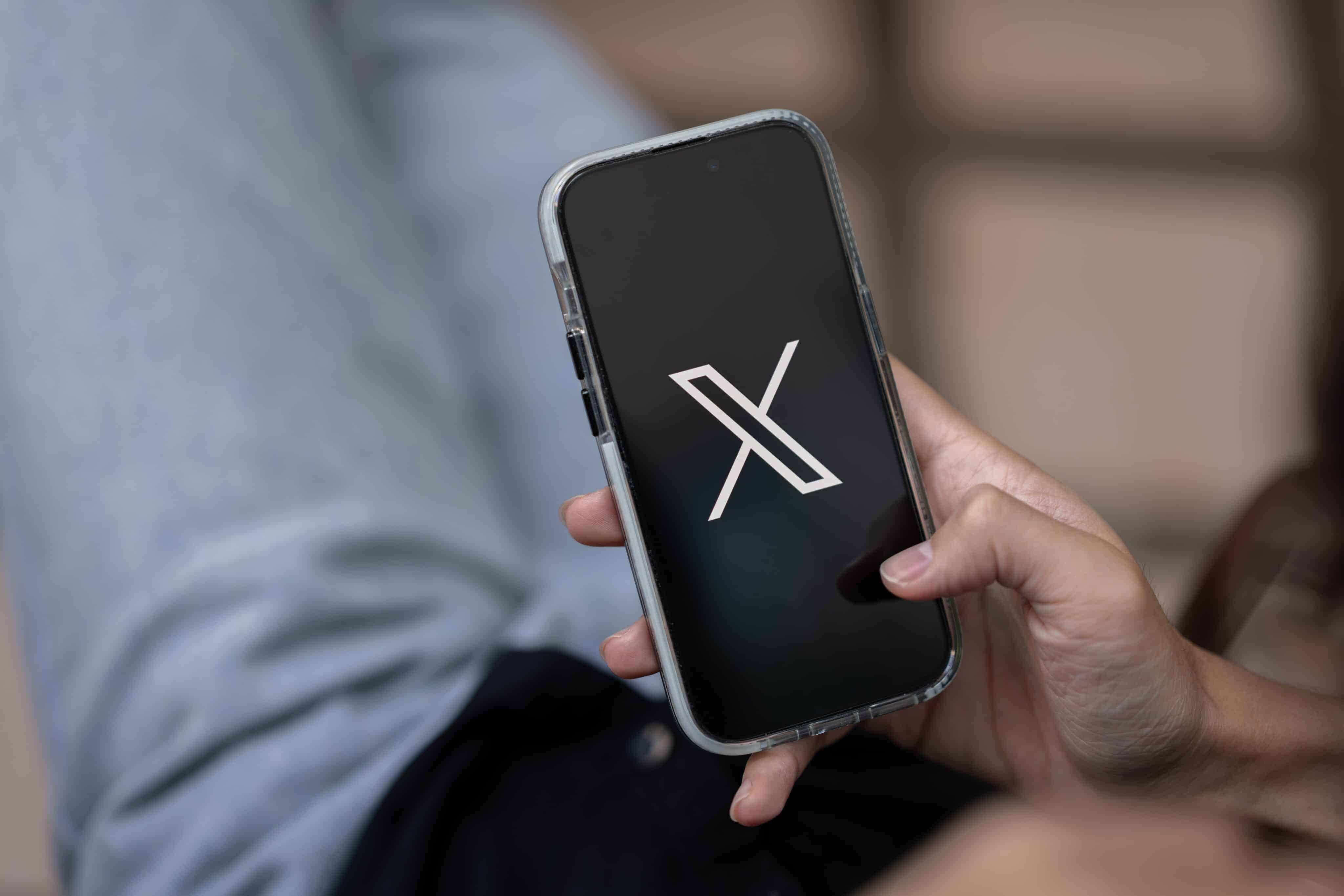 Homem usando o X em um iPhone