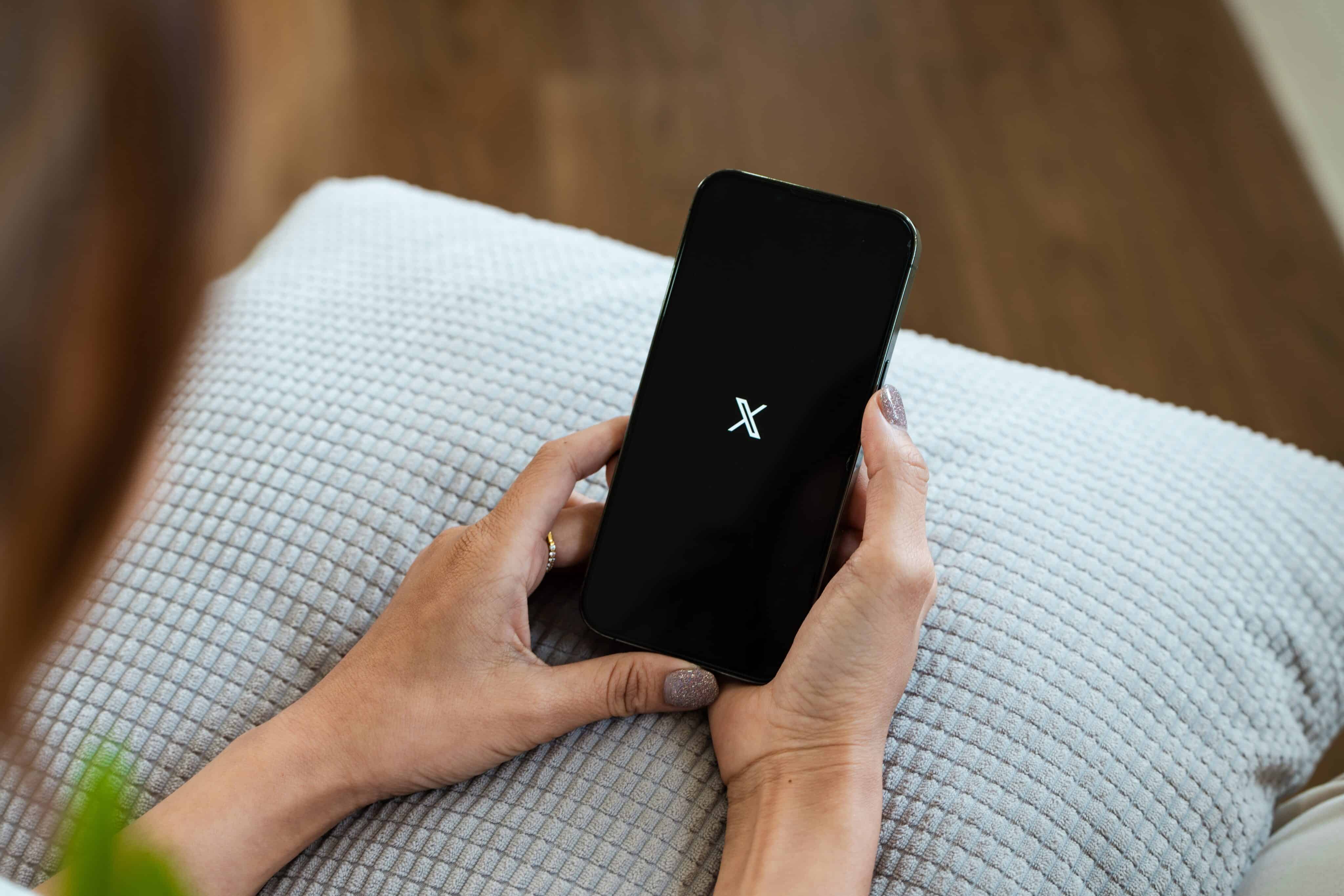 Mulher usando o X num iPhone 13 Pro