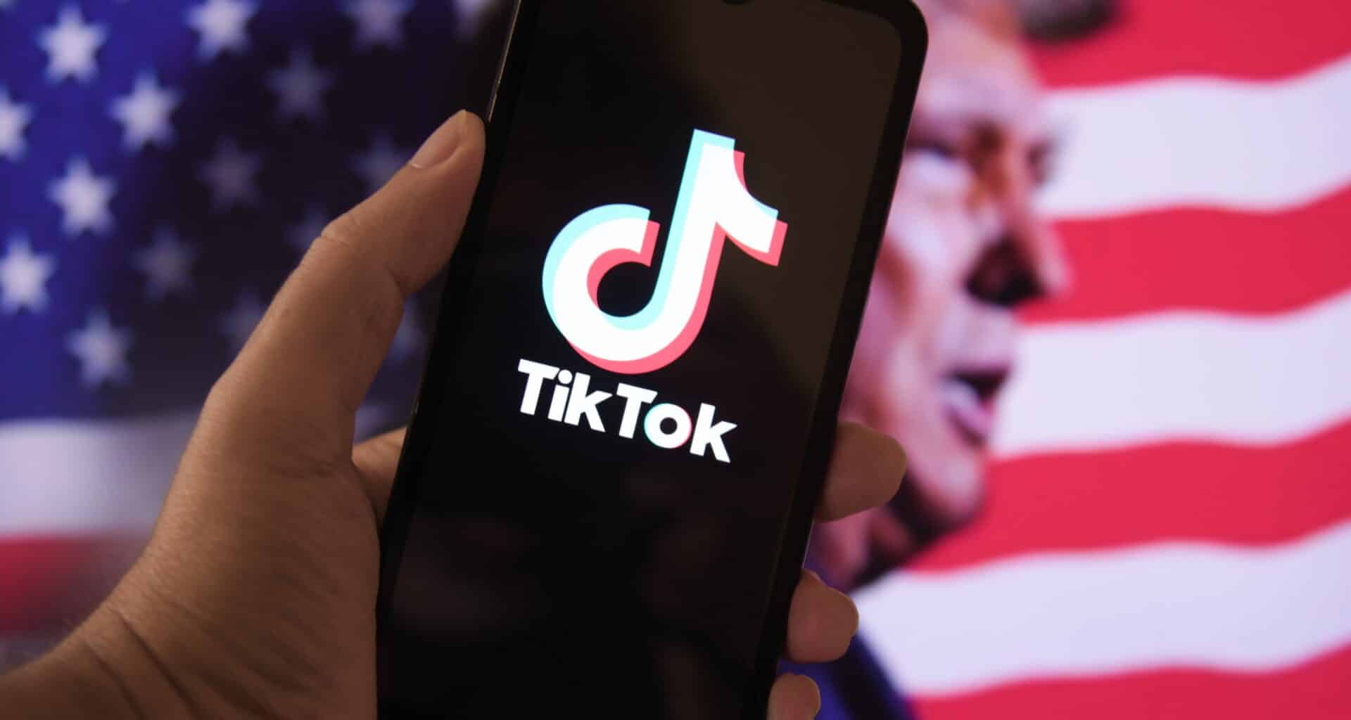 iPhone com o TikTok com uma bandeira dos EUA e Donald Trump ao fundo
