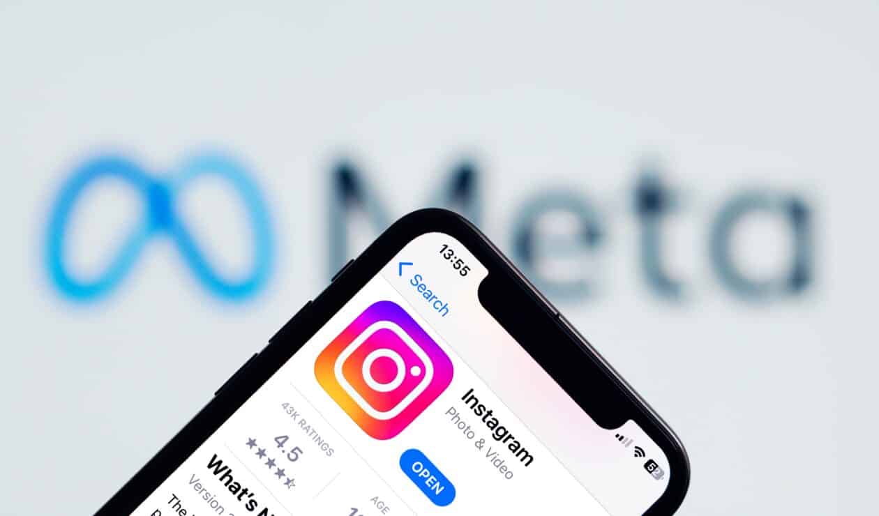 Instagram no iPhone com o logo da Meta ao fundo