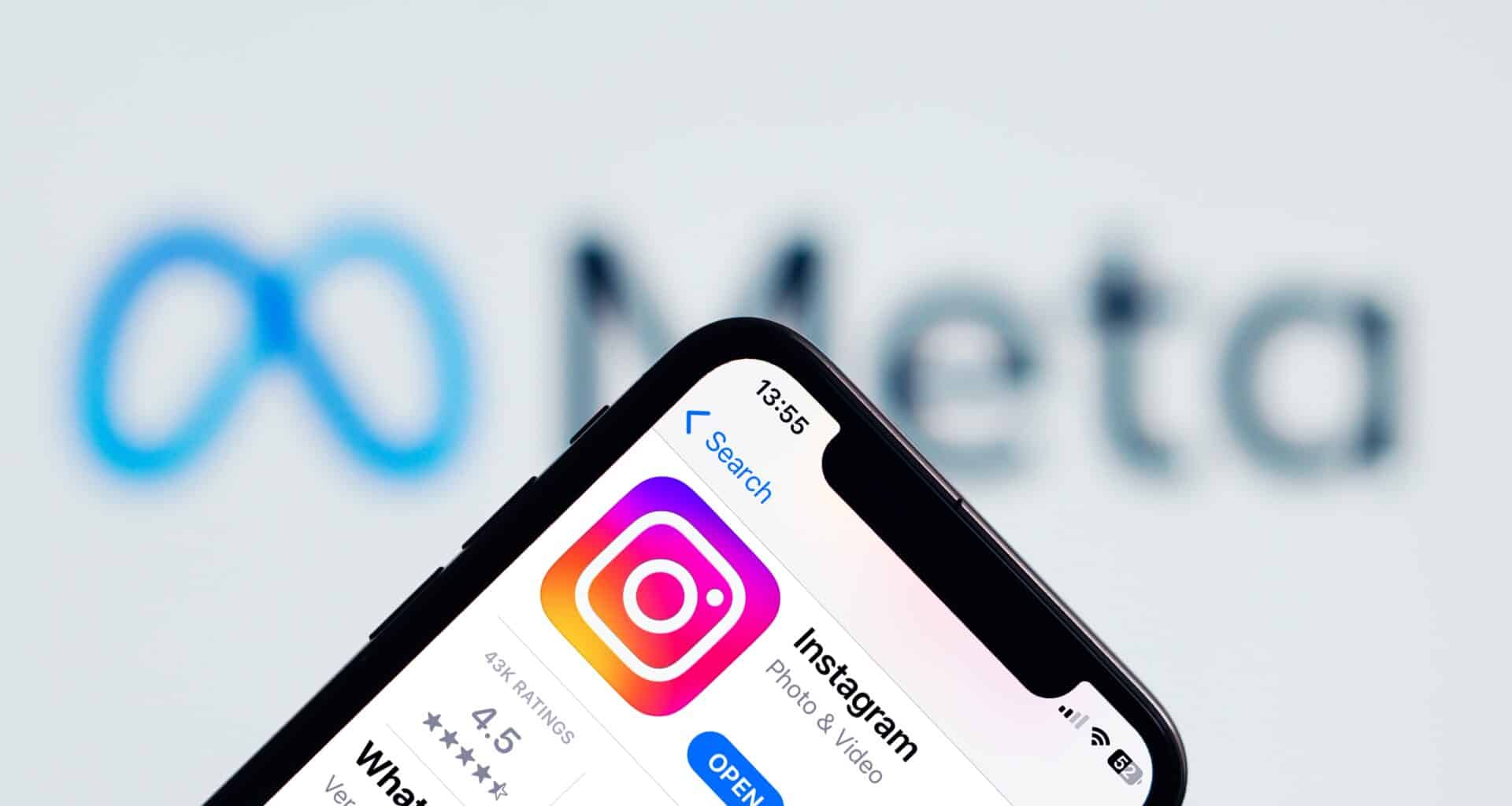 Instagram no iPhone com o logo da Meta ao fundo