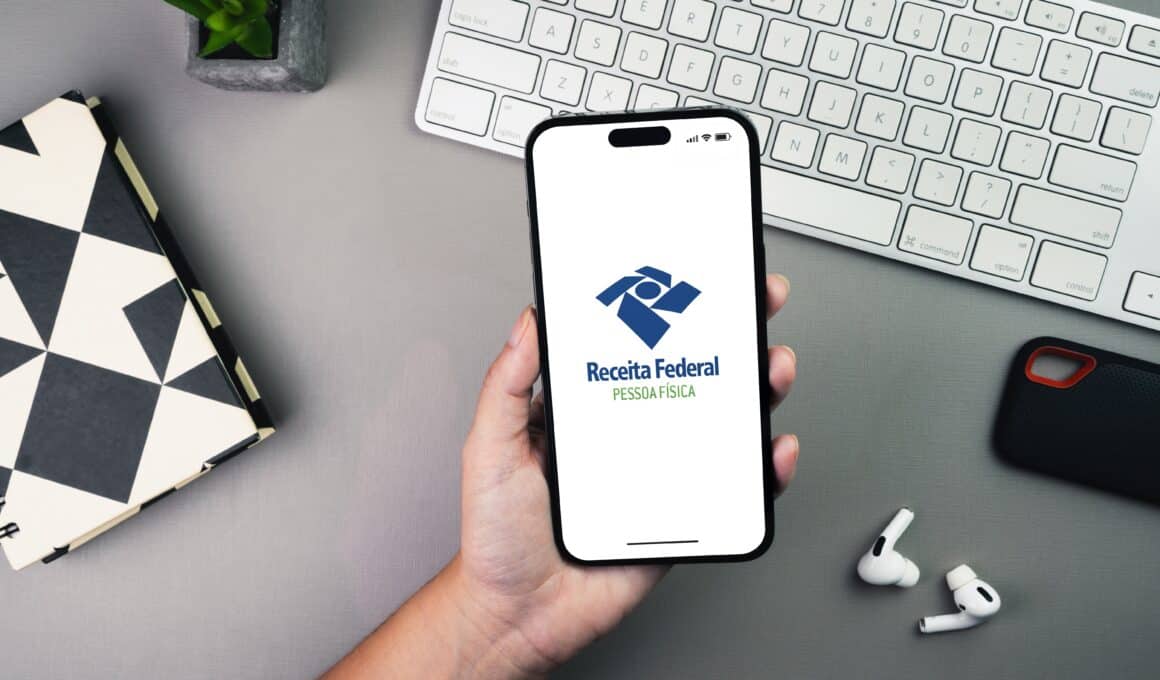 Mão segurando iPhone com Receita Federal/Pessoa Física