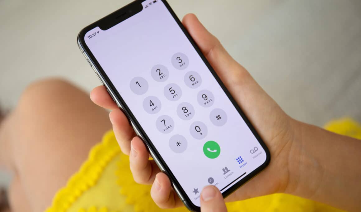 Mulher segurando um iPhone X para fazer uma ligação