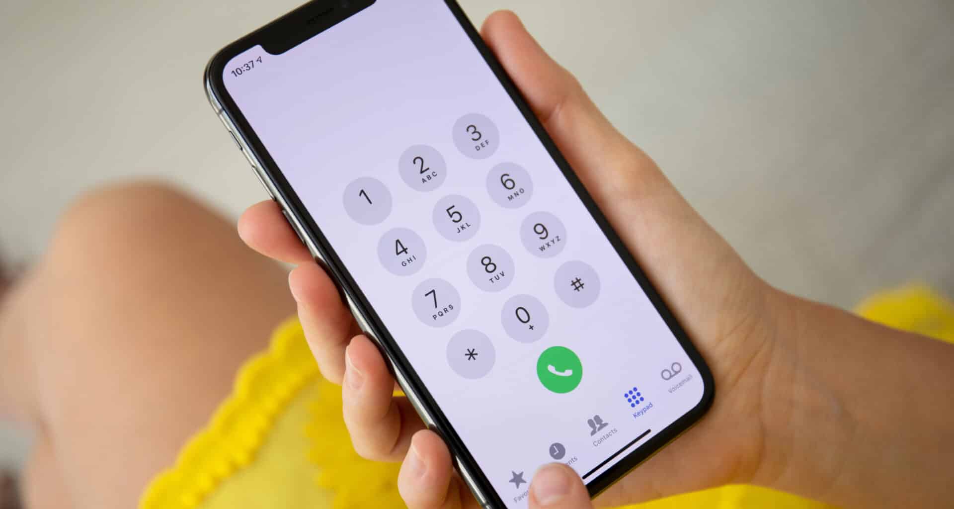 Mulher segurando um iPhone X para fazer uma ligação