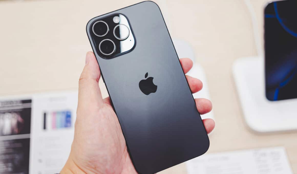 Mão segurando um iPhone 16 Pro Max e mostrando a parte de trás do aparelho