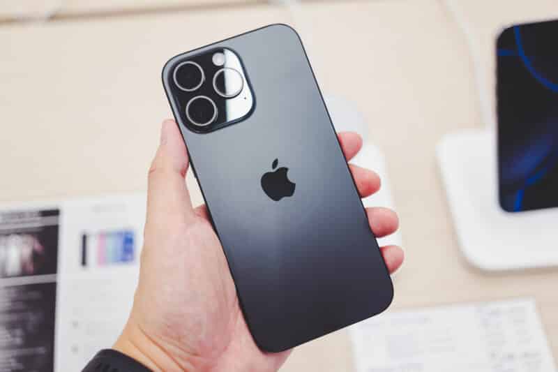 Mão segurando um iPhone 16 Pro Max e mostrando a parte de trás do aparelho