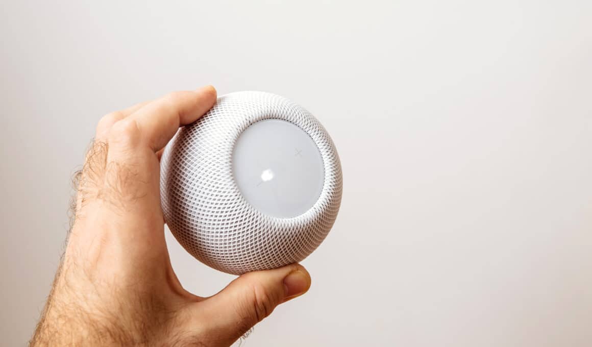 Homem segurando um HomePod mini branco