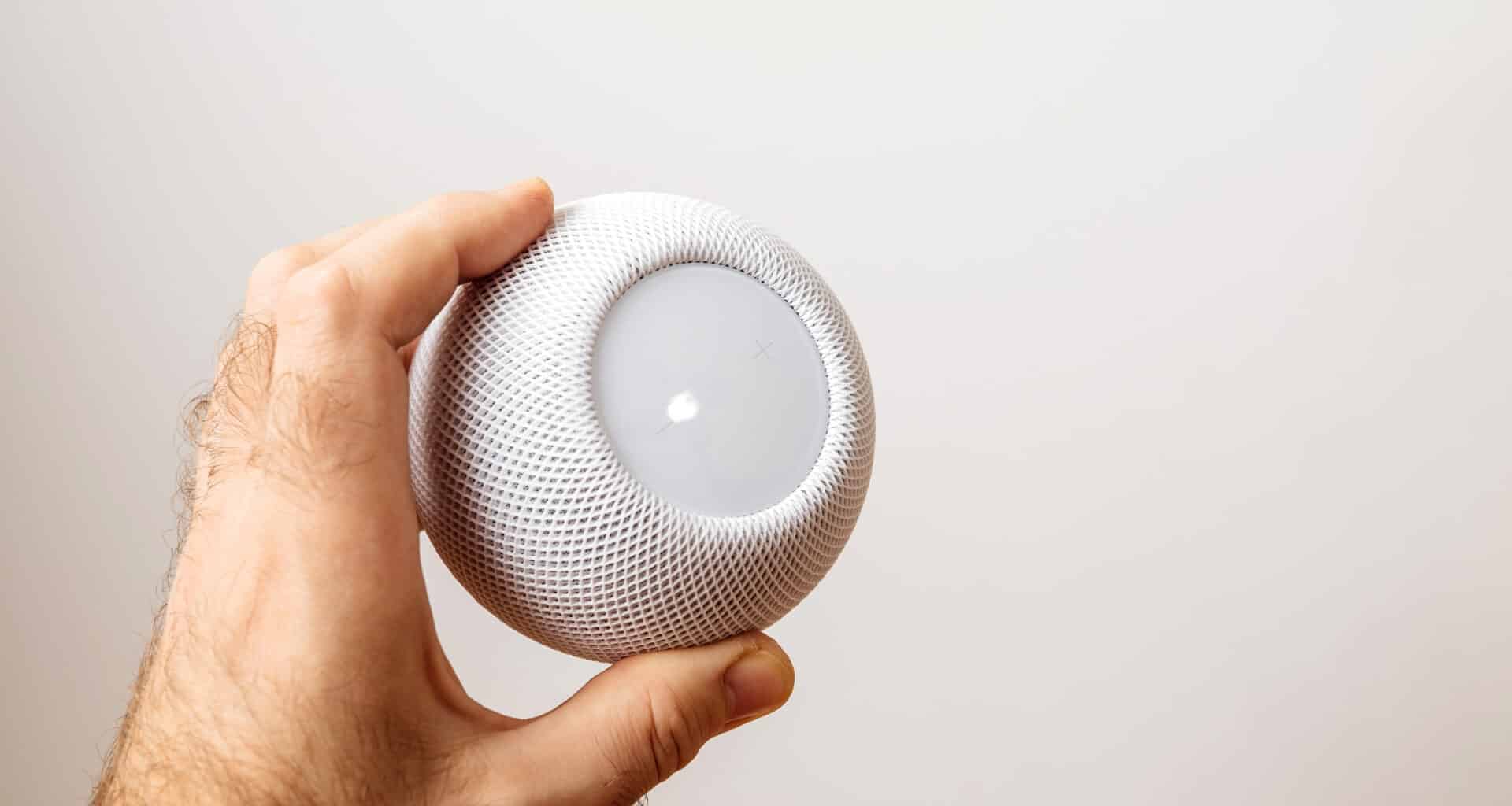 Homem segurando um HomePod mini branco