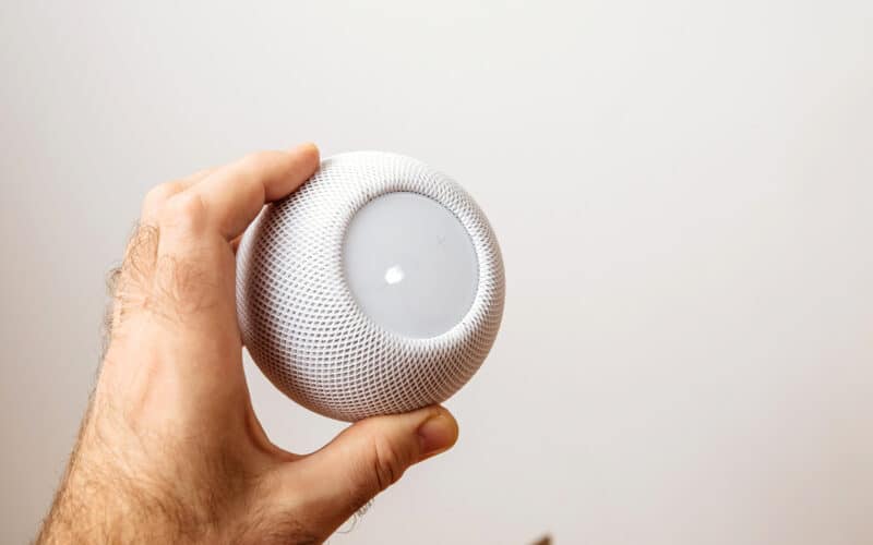 Homem segurando um HomePod mini branco