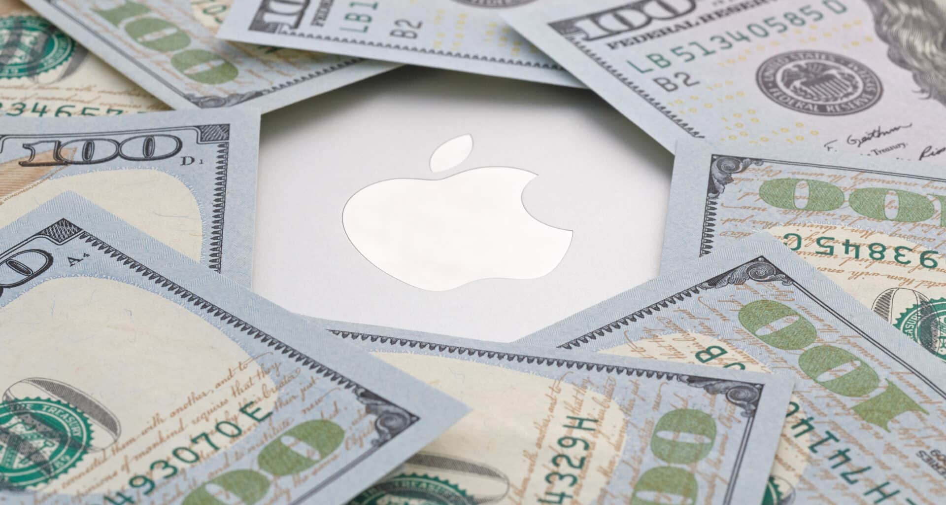 Dinheiro em cima de um MacBook Pro com o logo da Apple