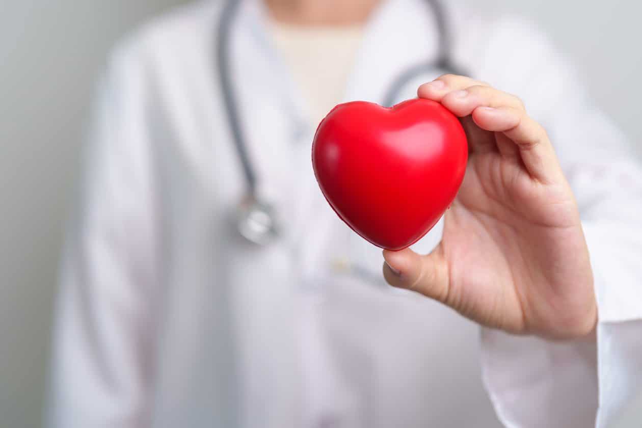 Médico segurando um coração de mentira, representando saúde