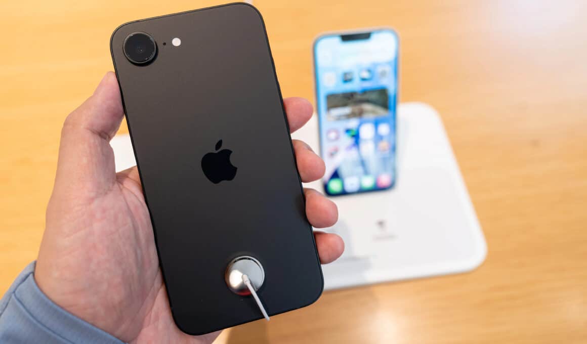 iPhone 16e em mãos numa Apple Store