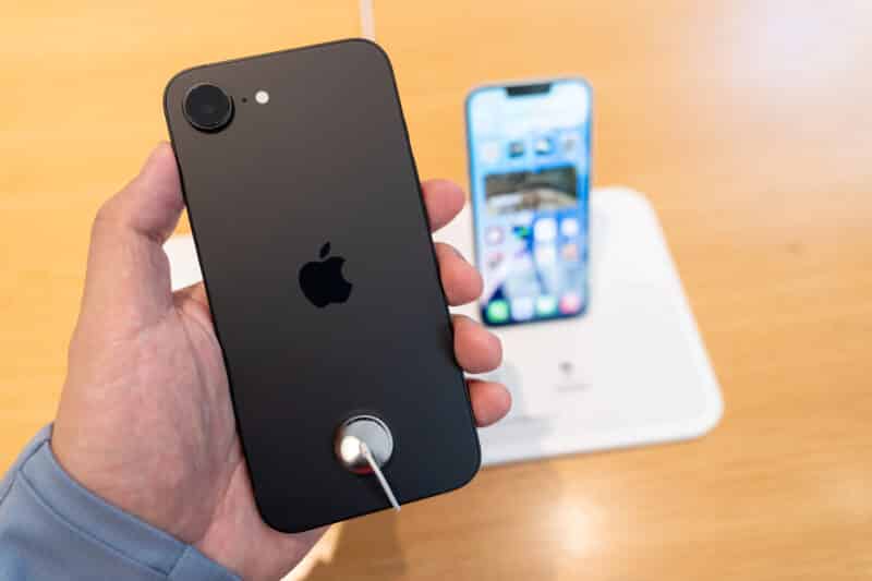 iPhone 16e em mãos numa Apple Store