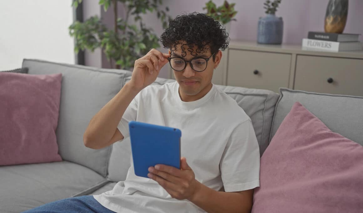Homem sentado no sofá lendo em um iPad