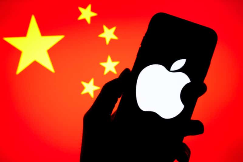Logo da Apple em um smartphone em frente à bandeira da China